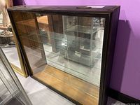 Front and angled view of the dark stained wood frame glass display case with clear glass shelves inside.