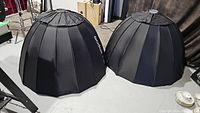 Two black Godox P120L collapsible parabolic softboxes side by side on floor.