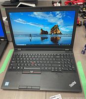 Front view of Lenovo ThinkPad P50 open and powered on showing desktop screen