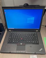 Opened laptop showing Windows desktop, keyboard, TrackPoint and fingerprint reader