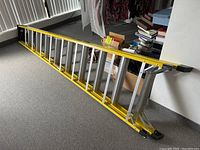 Full-length view of ladder collapsed horizontally on floor