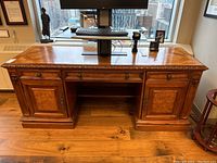 Front view of the antique style desk showing entire top surface and front cabinetry.