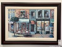 Full front view of framed painting showing Parisian street scene with bistro, dance centre and gallery