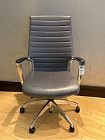Front view showing high-back ribbed vinyl upholstery and aluminum armrests.
