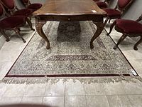 Full view of rug under table showing overall design and dimensions.