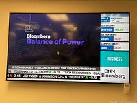 Wall-mounted 42-inch Samsung TV powered on showing Bloomberg news display