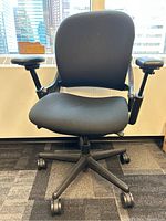 Front view of black Steelcase office chair showing seat, backrest, armrests and caster base