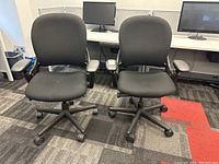 Front view of two chairs side by side in office environment