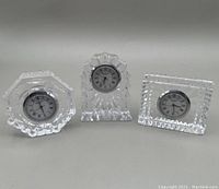 Front view of the three Waterford crystal clocks showing their distinct shapes and clock faces