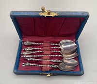Set of six vintage apostle coffee spoons displayed in blue fabric hinged box with red satin lining and worn securing band.