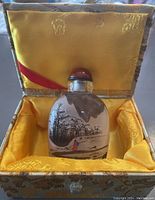 Snuff bottle seated inside the fitted box with yellow silk lining