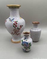 Three cloisonné vases shown together highlighting size differences and decorative patterns.