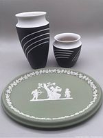 Photo showing two black and white Wedgwood vases and sage green Cupid and Psyche tray