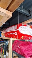 Large sealed red bag of Rockwool insulation stacked on wooden pallets in a storage area.