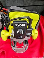 Front view of Ryobi router showing power rating and model information on variable speed control panel and black handles on each side.