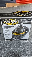Photo of the Stinger wet/dry vacuum box showing the vacuum's image and branding with model WD2025 and features.