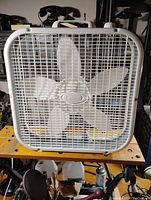 Front view of white Lasko box fan showing five blades and protective grill