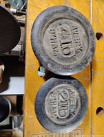 Top view of two cast iron scale weights, a 4 lb and a 2 lb, both labeled Avery B'HAM.