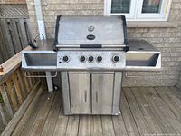 Front view of stainless steel Vermont Castings grill on wooden deck.