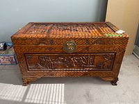 Front and top view of the carved wooden chest showing intricate relief scenes and metal lock.