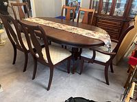Wide shot of six wood dining chairs around a matching dining table, showing overall style and condition.