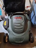 Top view of the electric lawn mower showing the brand label and some wear marks.