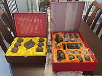 View of both tea sets open in their boxes showing all included items.