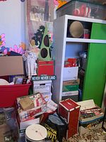 Wide shot of red tote, boxes, cabinet and tree box on green carpet