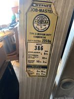 Close-up photo of the Werner Job-Master ladder label detailing the model (386), size, duty rating, and usage information.