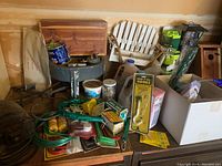 Wide view showing sander anchored to wooden table with assorted bird feeding and garden items around it including birdhouse, seed containers and tools.