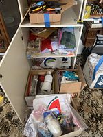 Full view of shelving and boxes containing yarn, fabrics, mason jars, string, and crafting supplies in basement craft room