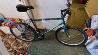 Teal Diamond Back Sorrento mountain bike shown indoors on carpeted floor with flat tires and black saddle.