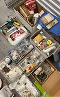 Overhead view of multiple bins containing fishing tackle, shells, minerals, jewelry and gem drill