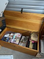Open wood trunk showing interior with bins, boxes and two lower drawers