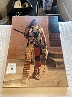 Full view of the Native American themed painting showing a man holding a rifle in traditional dress.