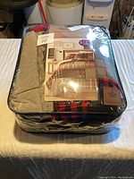 Image of packaged Canadian Lakes 3 piece king size quilt set with visible product label and patchwork pattern colors.