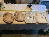 Four guitar blanks laid out on a surface with tape measure for size reference