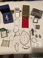 Full lot showing various jewelry pieces including watch, necklaces, bracelets, earrings, and crucifix