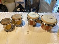 Four drums on table, two striped wood and two yellow, showing overall lot contents