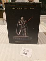 Front view of the box showing Darth Malgus statue image and label on a black background with some wear.