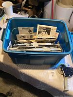Blue plastic bin filled with multiple Star Wars model kit parts and instruction sheets.