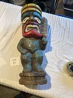 Front view showing the tiki man figure with detailed paint and expression