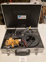 Underwater camera and black padded foam case open showing camera and cables inside