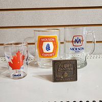 Photo showing the three beer glasses and the brass Labatt's belt buckle bottle opener placed in front of them.