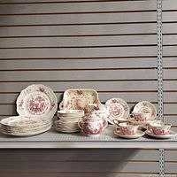 Full lot display of plates, cups, saucers, bowls, jug, and serving trays arranged on shelf