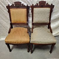 Front view of the pair of Eastlake chairs showing the woodwork and differing upholstery.