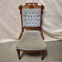 Front view of Victorian chair showing wooden frame and light blue seat cushion.