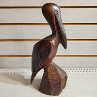 Front view of the entire stylized pelican carving on its base showing smooth finish and shape.