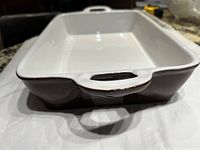 Close-up side view showing the dark brown ceramic exterior with slight glossy finish, handle detail with no chips or cracks visible