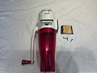 Top-down view of the antique Dazey ice crusher showing the hand crank, mounting block, and screws.